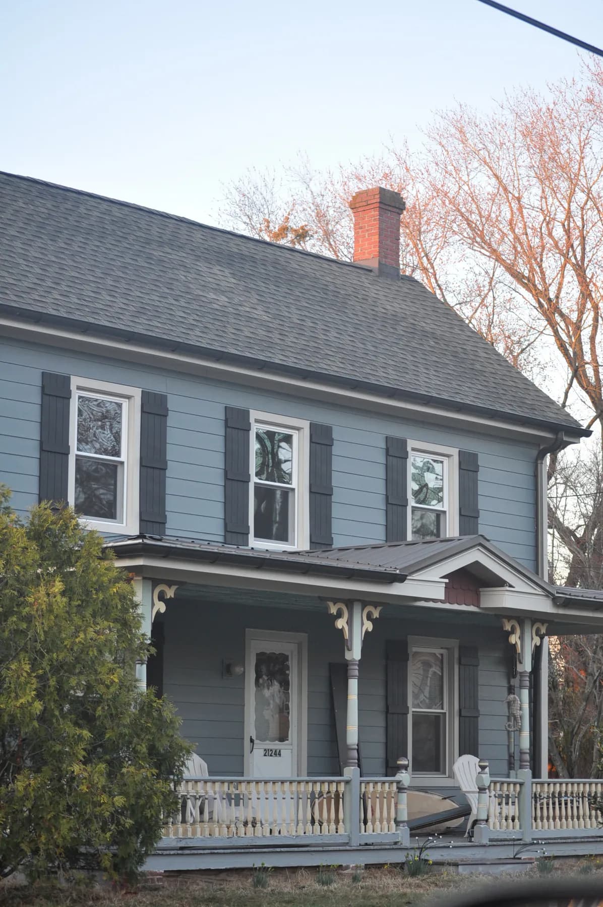 Blue clapboard house with black shutters under a new architectural shingle roof