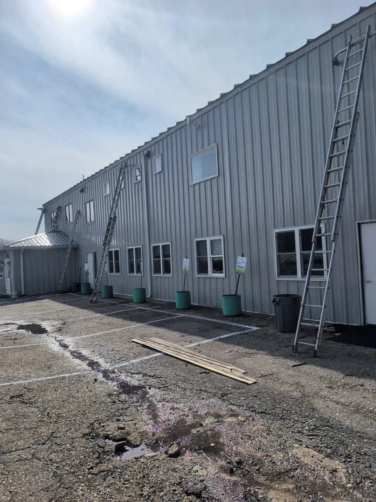 Side elevation of the same commercial building, ladders set against the eave